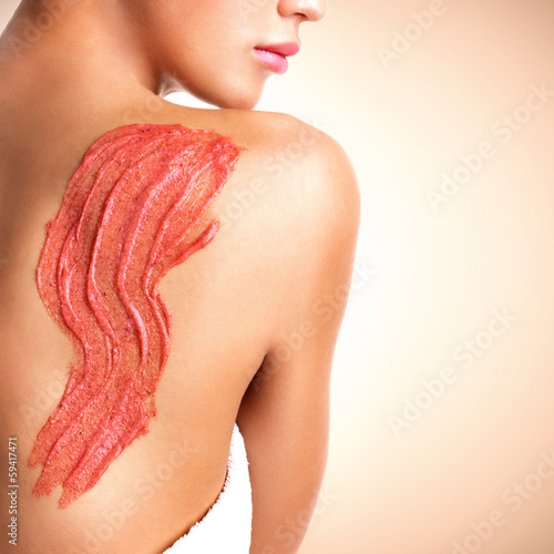 Photo: Beautiful young girl using a scrub. Beautiful young girl using a scrub.