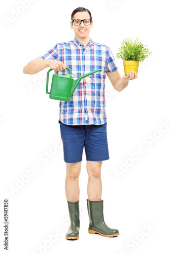 Photo: Male holding a watering can and a flower pot Male holding a watering can and a flower pot