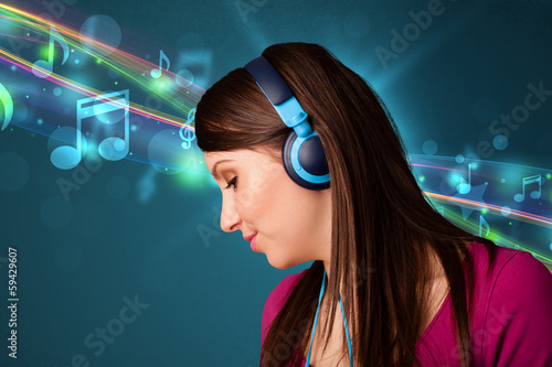 Photo: Young woman listening to music with headphones Young woman listening to music with headphones