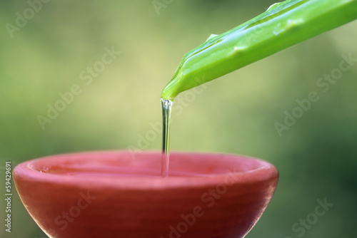 Photo: Falling aloe vera extract on a brown bowl Falling aloe vera extract on a brown bowl