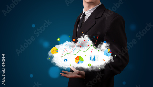 Photo: Young businessman presenting cloud with charts and graph icons a Young businessman presenting cloud with charts and graph icons a