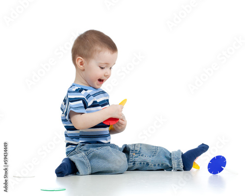 Photo: child boy playing with color toy over white background child boy playing with color toy over white background