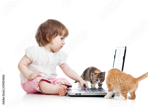 Photo: kid using a laptop and playing with kitten kid using a laptop and playing with kitten