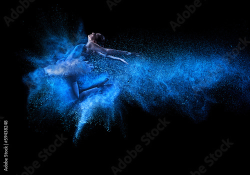  Young beautiful dancer jumping into blue powder cloud