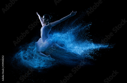  Young beautiful dancer jumping into blue powder cloud