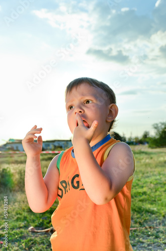 Photo: Young boy eating a stick of cotton candy Young boy eating a stick of cotton candy