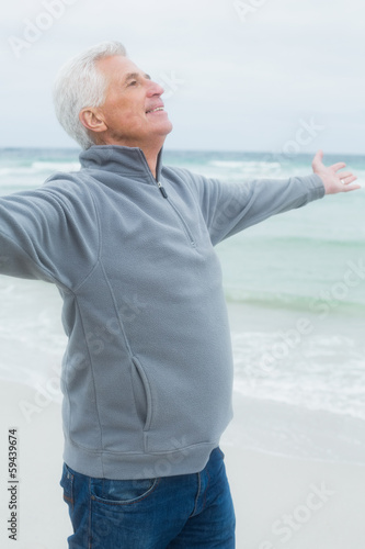 Photo: Senior man with arms outstretched at beach Senior man with arms outstretched at beach