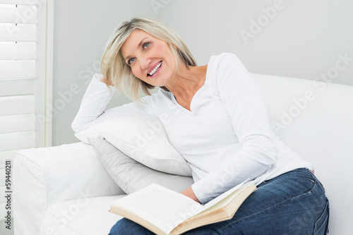 Photo: Happy woman with a book at home Happy woman with a book at home