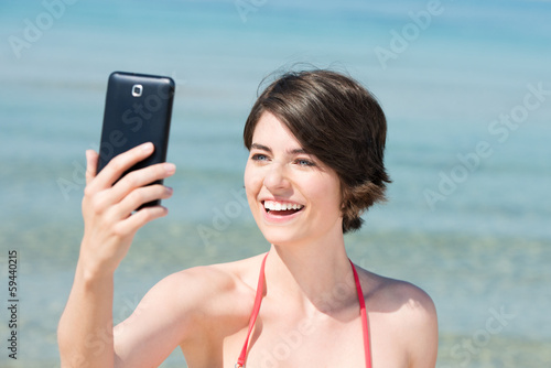 Photo: lachende frau fotografiert sich am meer lachende frau fotografiert sich am meer