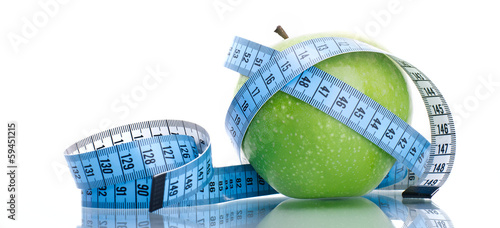 Photo: Dieting concept green apple with measuring tape Dieting concept green apple with measuring tape