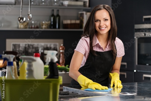 Photo: Beautiful woman in gloves cleaning modern kitchen Beautiful woman in gloves cleaning modern kitchen
