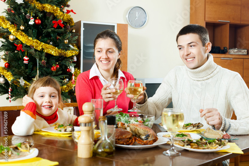 Photo: Happy family of three over celebratory table Happy family of three over celebratory table