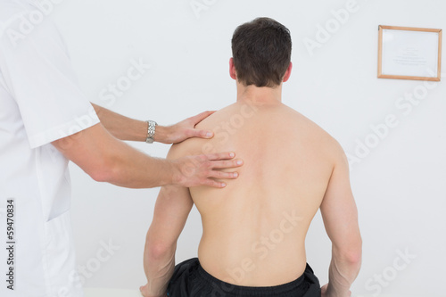 Photo: Shirtless man being massaged by a physiotherapist Shirtless man being massaged by a physiotherapist