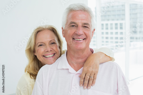 Photo: Happy senior woman embracing man from behind Happy senior woman embracing man from behind