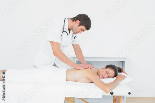 Photo: Male physiotherapist massaging woman's back Male physiotherapist massaging woman's back