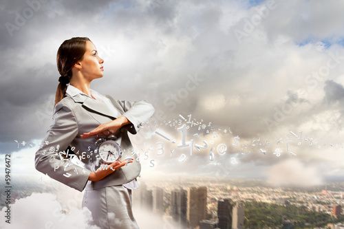 Photo: Businesswoman holding alarmclock Businesswoman holding alarmclock