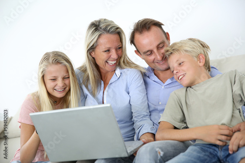 Photo: Family connected on internet with laptop Family connected on internet with laptop
