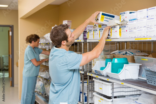 Photo: Nurses Arranging Stock In Storage Room Nurses Arranging Stock In Storage Room