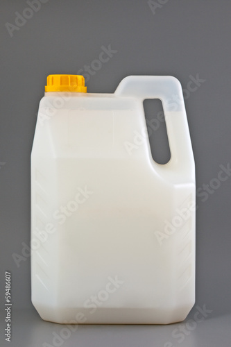 Photo: Transparent detergent plastic bottle isolated on gray Transparent detergent plastic bottle isolated on gray