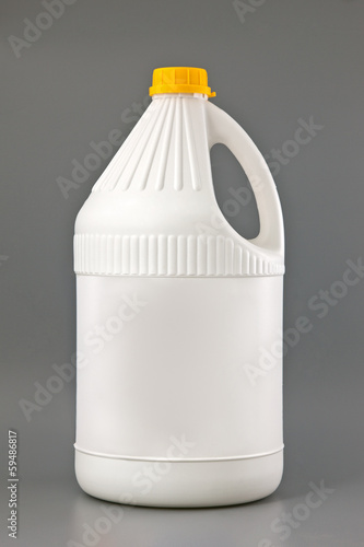 Photo: White detergent plastic bottle isolated on gray White detergent plastic bottle isolated on gray