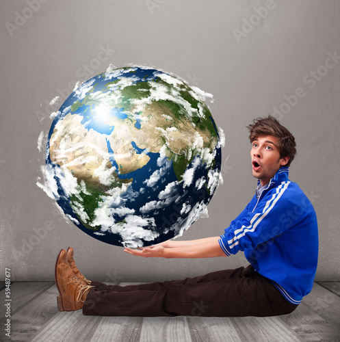 Photo: Good-looking man holding 3d planet earth Good-looking man holding 3d planet earth
