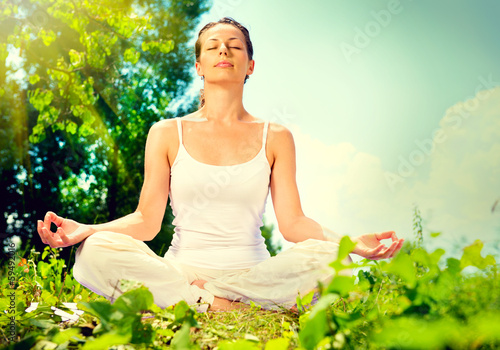 Photo: Young woman doing yoga exercise outdoor Young woman doing yoga exercise outdoor