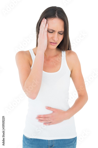 Photo: Displeased woman with stomach pain and headache Displeased woman with stomach pain and headache