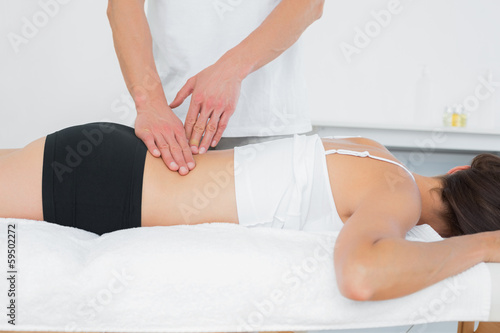 Photo: Male physiotherapist massaging woman's back Male physiotherapist massaging woman's back