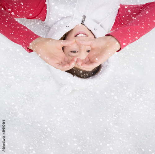 Photo: Kind liegt im Winter im Schnee mit Herz Kind liegt im Winter im Schnee mit Herz