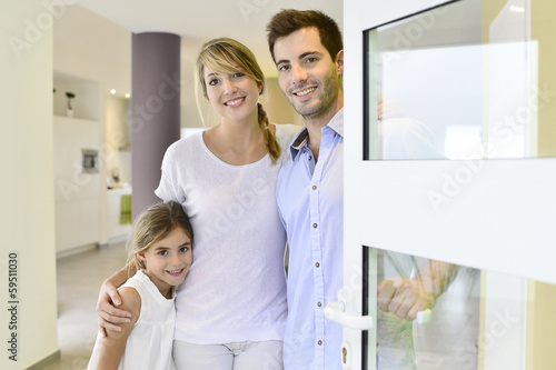Photo: Family standing at front door to invite people in Family standing at front door to invite people in