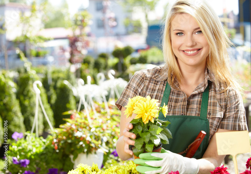 Photo: Florists woman working with flowers at a greenhouse. Florists woman working with flowers at a greenhouse.