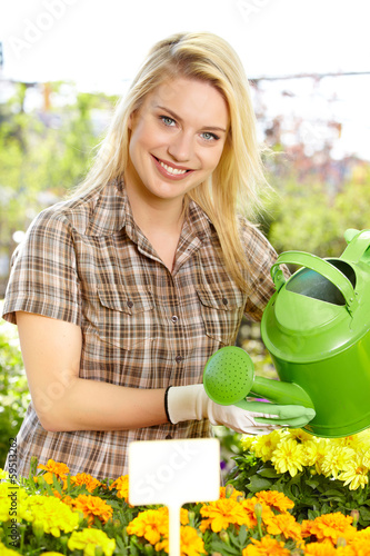Photo: Florists woman working with flowers at a greenhouse. Florists woman working with flowers at a greenhouse.