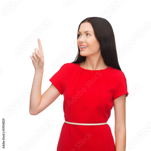 Photo: young woman in red dress pointing her finger young woman in red dress pointing her finger