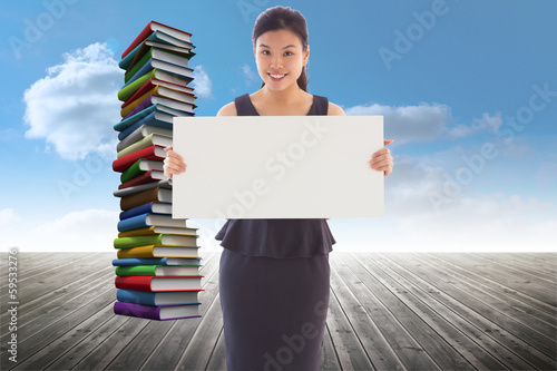 Photo: Composite image of businesswoman holding a placard Composite image of businesswoman holding a placard
