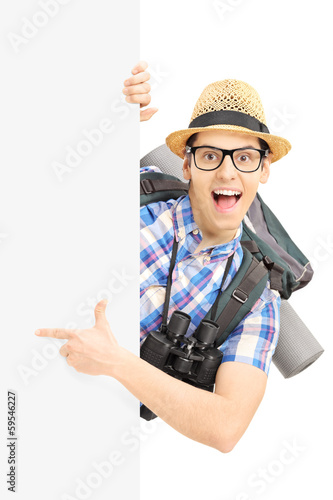 Photo: Smiling male tourist pointing on a blank panel Smiling male tourist pointing on a blank panel