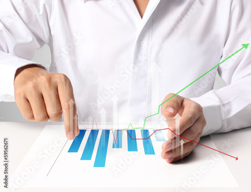 Photo: Business man pushing graph Business man pushing graph