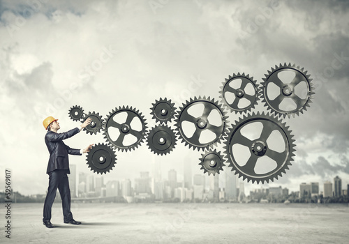 Photo: Businessman and mechanism elements Businessman and mechanism elements