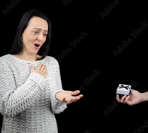 Photo: Appreciative woman receiving gift, black background Appreciative woman receiving gift, black background