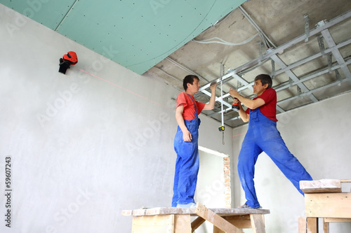 Photo: builders set the ceiling profile in the new apartment builders set the ceiling profile in the new apartment