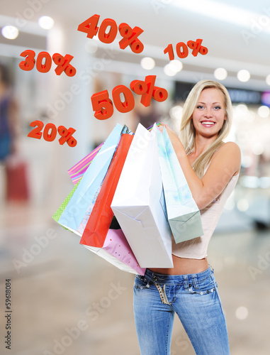 Photo: Woman with shopping bags poses at store Woman with shopping bags poses at store