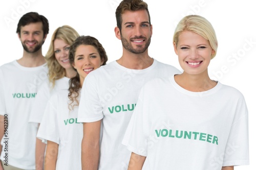 Photo: Group portrait of happy volunteers standing in a row Group portrait of happy volunteers standing in a row