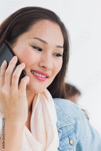 Photo: Beautiful casual young woman using mobile phone in office Beautiful casual young woman using mobile phone in office