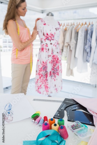 Photo: Female fashion designer working on floral dress at studio Female fashion designer working on floral dress at studio