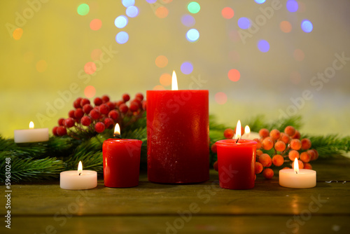 Photo: Candles and Christmas decoration on bright background Candles and Christmas decoration on bright background