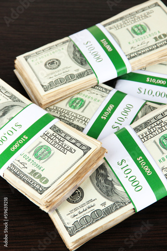 Photo: Stacks of money on wooden table Stacks of money on wooden table