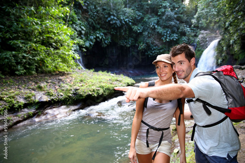 Photo: Trekkers reaching waterfall in natural landscape Trekkers reaching waterfall in natural landscape