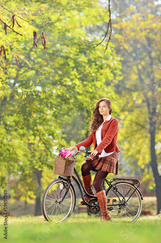 Photo: Beautiful female on a bicycle in a park Beautiful female on a bicycle in a park