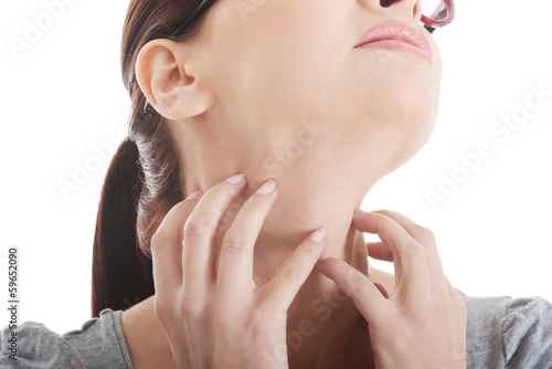 Photo: Young woman is scratching her neck. Young woman is scratching her neck.
