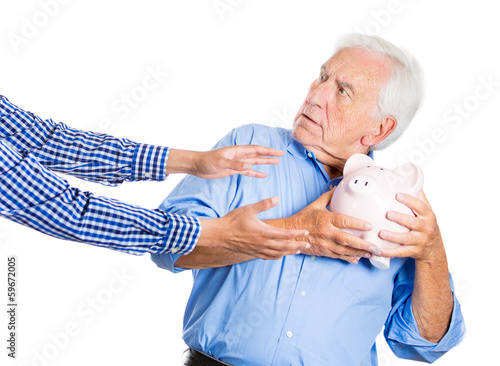 Photo: Senior man protecting piggy bank, savings from being stolen Senior man protecting piggy bank, savings from being stolen