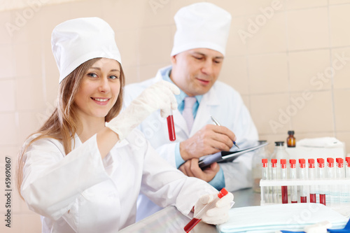 Photo: Positive nurse and male doctor works with test tubes Positive nurse and male doctor works with test tubes